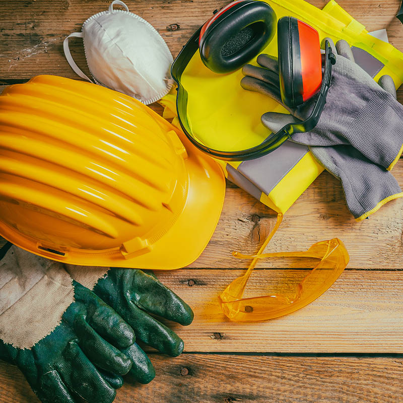A hardhat, gloves, and safety glasses laying on a table.